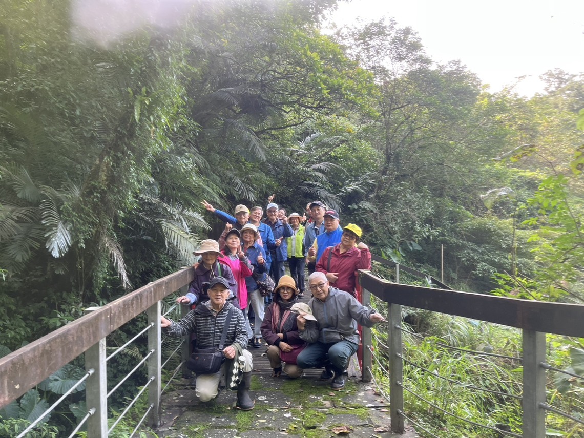 中和農會與民眾團體17人參訪國家藥用植物園，成員站立於綠意盎然的山林步道橋上合影，氣氛愉快自然。圖片