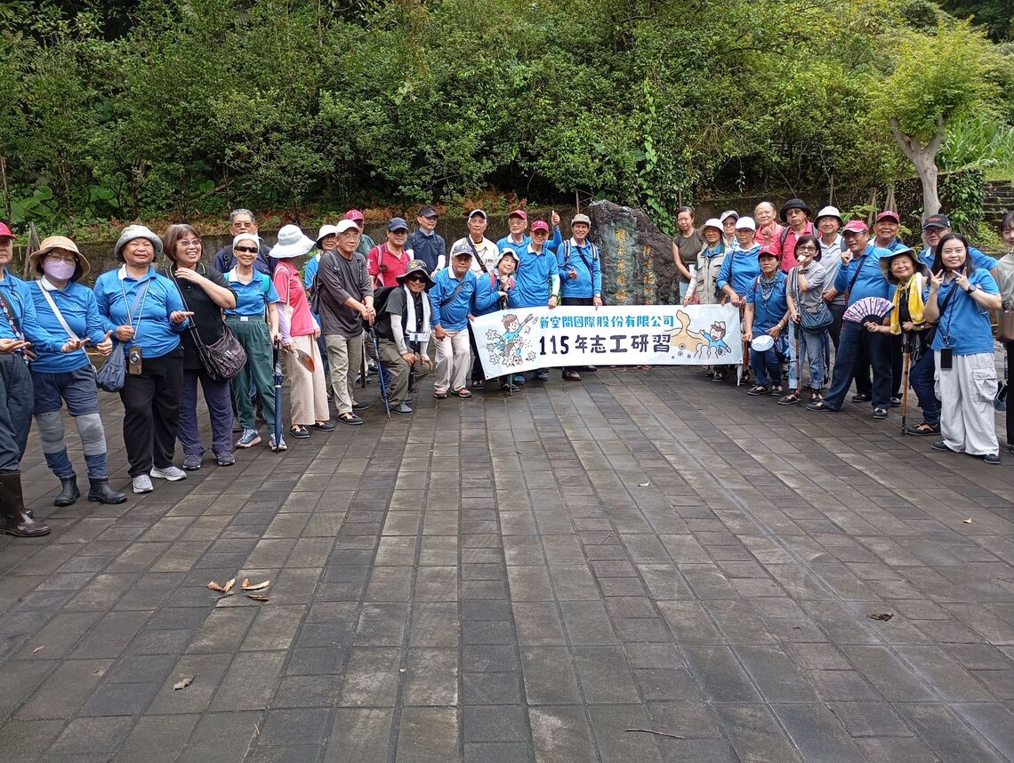 民眾團體於衛生福利部『國家藥用植物園』石碑前手持『115年志工研習』紅布條開心合影。圖片