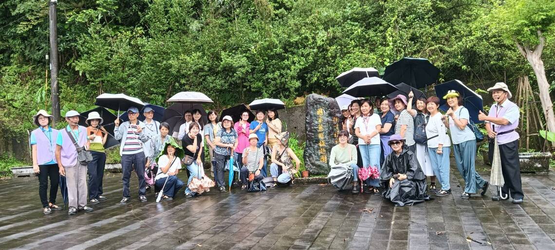 2026年9月10日民眾團體40人參訪，於雨中撐傘在衛生福利部『國家藥用植物園』石碑前合影。圖片